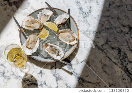 Fresh oysters on ice with champagne in sunlight Fresh oysters on ice with champagne in sunlight 138130820