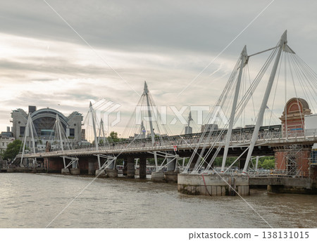 A striking architectural dialogue unfolds across the River Thames, where the industrial legacy of the Hungerford Bridge meets the modern elegance of the Golden Jubilee Footbridges. A striking architectural dialogue unfolds across the River Thames, where the industrial legacy of the Hungerford Bridge meets the modern elegance of the Golden Jubilee Footbridges. 138131015