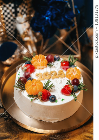 White Frosted Cake With Tangerines And Raspberries On Gold Plate, Rosemary Sprigs Fresh Cream Glaze White Frosted Cake With Tangerines And Raspberries On Gold Plate, Rosemary Sprigs Fresh Cream Glaze 138131278