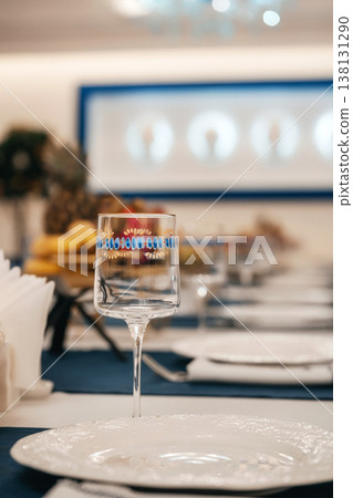 Photograph Capturing Branded Wine Glass With Refined Banquet Background And Sommelier Preparing Photograph Capturing Branded Wine Glass With Refined Banquet Background And Sommelier Preparing 138131290