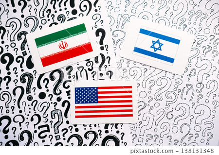 Three cards showing flags of IRAN, ISRAEL, and USA rest on background of hand drawn question marks. USA Israel Iran, Middle East crisis, trilateral relations, International security. Three cards showing flags of IRAN, ISRAEL, and USA rest on background of hand drawn question marks. USA Israel Iran, Middle East crisis, trilateral relations, International security. 138131348