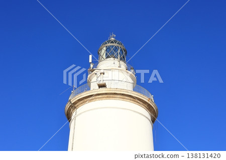 A view of the lighthouse of Malaga. The lighthouse is an iconic 19th-century lighthouse located at the entrance to the Port of Malaga. 138131420