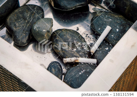 Ashtray With Cigarette Butts On Pebbles After Outdoor Smoking Break Stained Ceramic Tray Damp Dark . 138131594