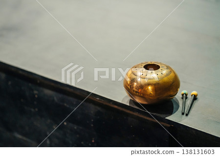 Brass Bowl And Mallets Onstage, Closeup Detail Of Patina And Dented Surface, Stage Floor Texture . Brass Bowl And Mallets Onstage, Closeup Detail Of Patina And Dented Surface, Stage Floor Texture . 138131603