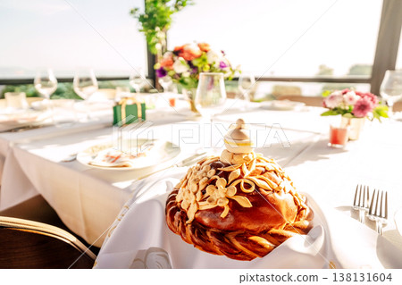 Sunlit Seaside Table With Braided Almond Loaf Floral Arrangement And Glassware On Terrace . Sunlit Seaside Table With Braided Almond Loaf Floral Arrangement And Glassware On Terrace . 138131604
