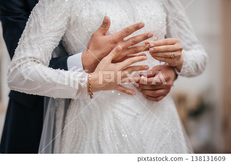 Tender Hands Intertwined Over Sequin Gown With Rings And Floral Background, Gentle Support . Tender Hands Intertwined Over Sequin Gown With Rings And Floral Background, Gentle Support . 138131609