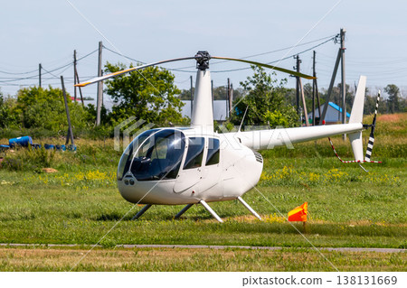 Private small white helicopter on green field in the countryside Private small white helicopter on green field in the countryside 138131669