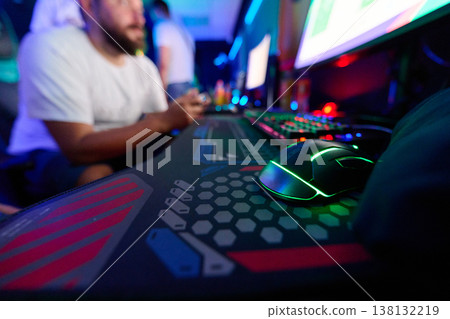 Gamer Using RGB Gaming Mouse And Keyboard At LAN Party With Console Controller And Monitors 138132219