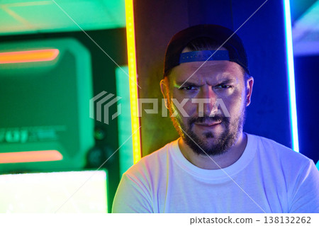 Serious Bearded Man Portrait in Cap With Colorful Neon Lights and Urban Night Mood Serious Bearded Man Portrait in Cap With Colorful Neon Lights and Urban Night Mood 138132262