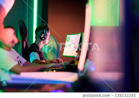 Competitive Gaming Team Playing Esports Tournament on Computers With Headsets in Neon Arena Competitive Gaming Team Playing Esports Tournament on Computers With Headsets in Neon Arena 138132283