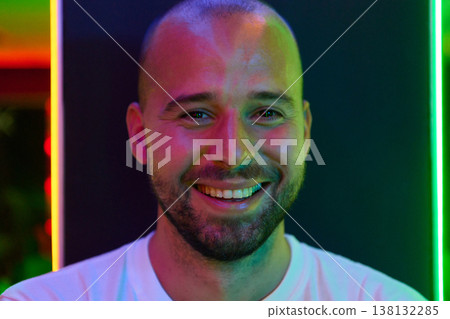 Smiling Young Man Portrait With Colorful Neon Lighting Vibrant Casual Headshot in Nightlife Setting Smiling Young Man Portrait With Colorful Neon Lighting Vibrant Casual Headshot in Nightlife Setting 138132285