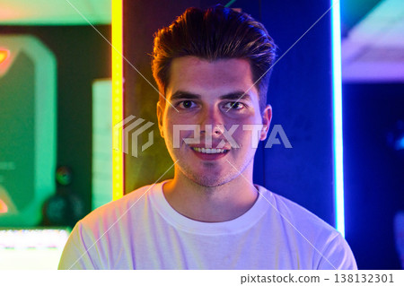 Smiling Young Man Portrait in Neon Lights With Casual White T Shirt and Modern Studio Vibe Smiling Young Man Portrait in Neon Lights With Casual White T Shirt and Modern Studio Vibe 138132301