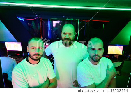 Confident Gaming Team of Three Friends in Neon Esports Room Wearing White T-Shirts 138132314