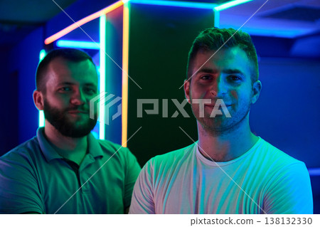 Two Young Friends Smiling Portrait in Neon-Lit Room With Colorful LED Lights and Casual Style Two Young Friends Smiling Portrait in Neon-Lit Room With Colorful LED Lights and Casual Style 138132330