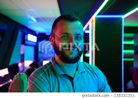 Confident Gamer Portrait in Neon Lit Esports Arcade With Modern LED Lighting and Casual Style Confident Gamer Portrait in Neon Lit Esports Arcade With Modern LED Lighting and Casual Style 138132351