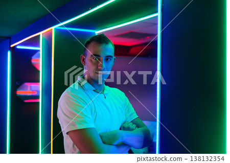 Confident Young Man Portrait in Neon Lit Club Corridor With Colorful LED Lights Confident Young Man Portrait in Neon Lit Club Corridor With Colorful LED Lights 138132354