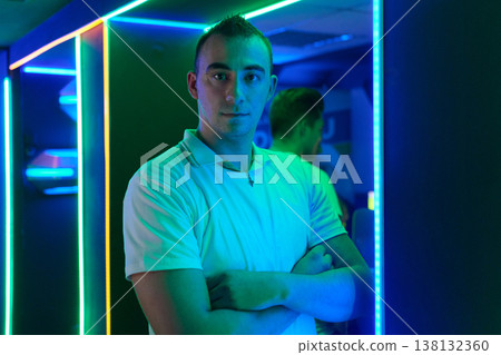Confident Young Man Portrait in Neon Lights at Night Club With Arms Crossed Confident Young Man Portrait in Neon Lights at Night Club With Arms Crossed 138132360