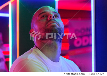 Contemplative Man Looking Up in Neon Portrait With Colorful LED Nightlife Lighting Contemplative Man Looking Up in Neon Portrait With Colorful LED Nightlife Lighting 138132424
