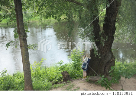 Young observer outdoors. Youth studies nature by tranquil stream Young observer outdoors. Youth studies nature by tranquil stream 138133951