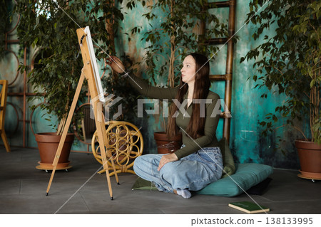 Caucasian female artist engaged in peaceful painting session Caucasian female artist engaged in peaceful painting session 138133995
