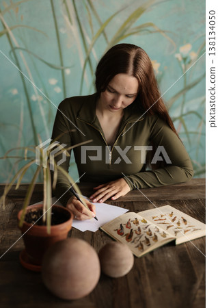 Young woman creating watercolor plant illustrations in studio 138134050