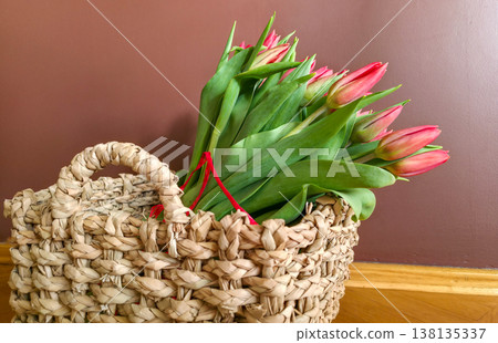 Red tulips in a basket close-up. A gift for a girl for the holidays. High quality photo 138135337