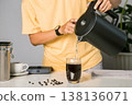 Man making use kettle pouring hot water making iced coffee or cold americano coffee into the cup with equipment, tool digital scale on the wooden bar at kitchen home 138136071