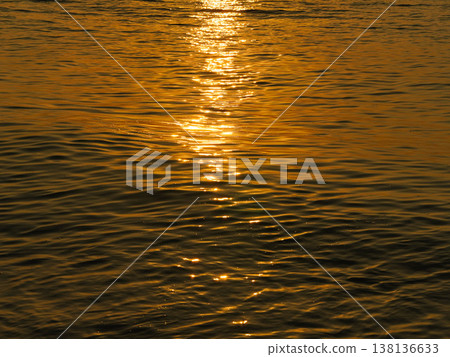 Golden sunset reflection on calm sea water surface abstract nature background. Golden sunset reflection on calm sea water surface abstract nature background. 138136633