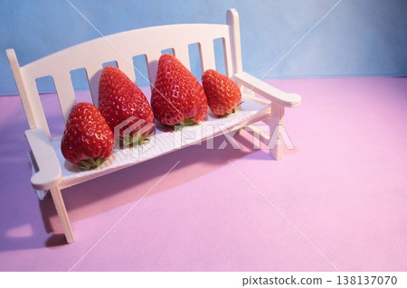 Strawberries lined up on a white chair 138137070