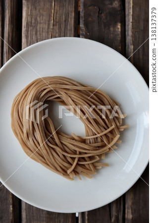 Healthy brown rice noodles before boiling; gluten-free noodles 138137379