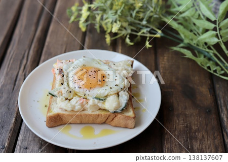 Open-faced sandwich with potato salad drizzled in olive oil and a fried egg. Open-faced sandwich with potato salad drizzled in olive oil and a fried egg. 138137607