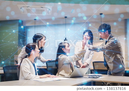 一位女士欣喜若狂,在辦公室與其他人擊掌慶祝。 一位女士欣喜若狂,在辦公室與其他人擊掌慶祝。 138137816