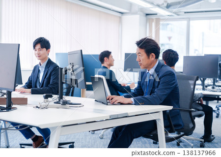 A male office worker working in a brightly lit office 138137966