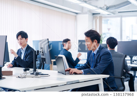 A male office worker working in a brightly lit office 138137968