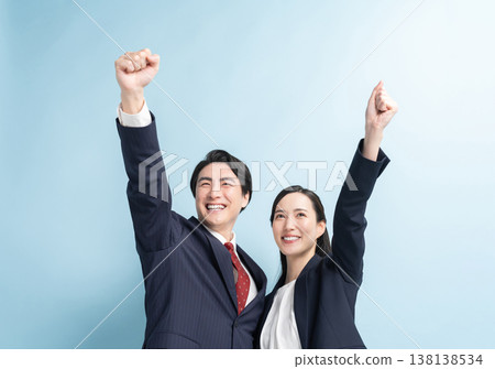 A smiling businessman and his wife make a victory pose. 138138534