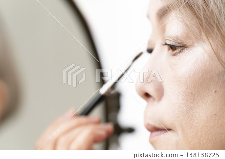 Senior women applying makeup 138138725