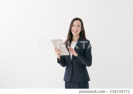 A woman giving directions while holding a tablet PC. A woman giving directions while holding a tablet PC. 138138772