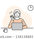 一位微笑的女士一邊在電腦前工作，一邊比出「OK」手勢。 138138883