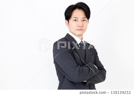 A middle-aged businessman with his arms crossed. 138139252