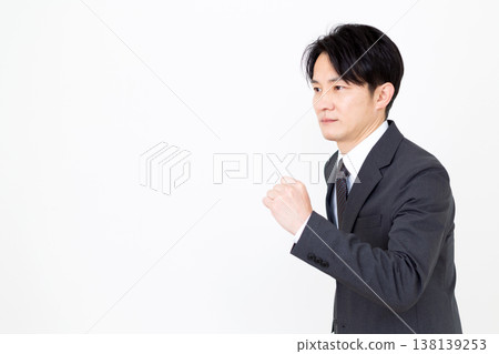 A middle-aged businessman in a suit strikes a running pose. A middle-aged businessman in a suit strikes a running pose. 138139253