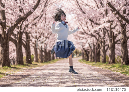 Female students jumping in a row of cherry trees Female students jumping in a row of cherry trees 138139470