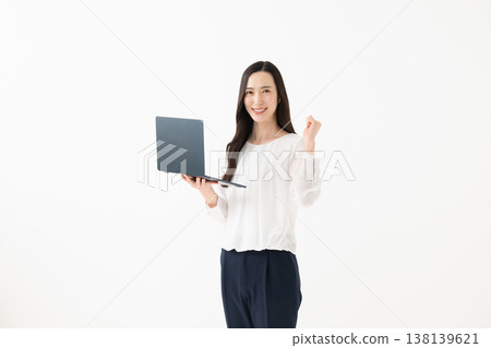 一名女子手持筆記型電腦，做出勝利的手勢。 138139621