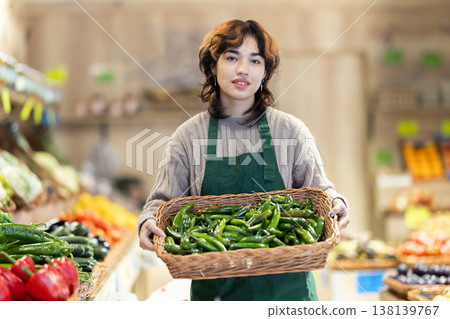 Girl seller in grocery vegetable shop arrange pepper case 138139767