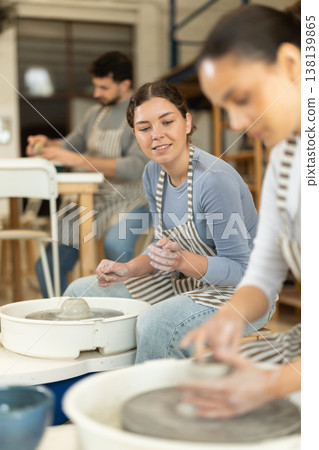 Woman in ceramics workshop with pottery wheel and various clay vessels Woman in ceramics workshop with pottery wheel and various clay vessels 138139865