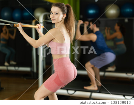 Young woman doing squats on reformer Young woman doing squats on reformer 138139913