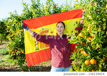 Girl football fan waving Spanish flag during tangerines harvest Girl football fan waving Spanish flag during tangerines harvest 138139914