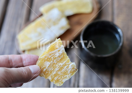 我用指尖從茨城撕下一塊曬乾的紅薯,把它拿起來。 我用指尖從茨城撕下一塊曬乾的紅薯,把它拿起來。 138139999