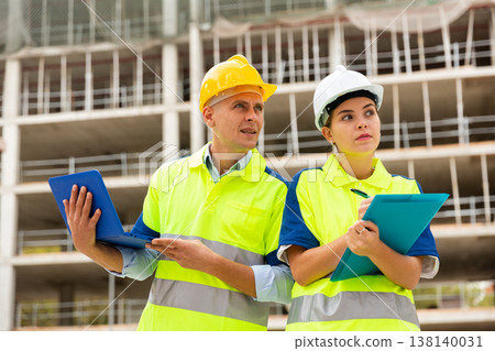 Two architects with laptop discussing construction plan Two architects with laptop discussing construction plan 138140031