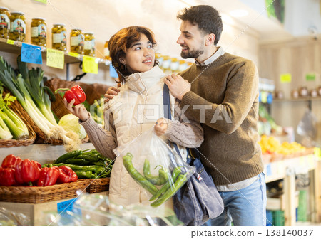 Young couple choosing peppers in store Young couple choosing peppers in store 138140037