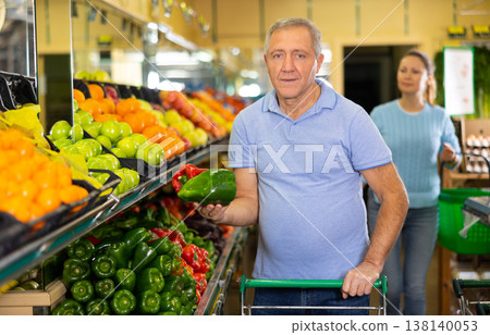 Elderly man purchaser buying pepper in grocery store Elderly man purchaser buying pepper in grocery store 138140053